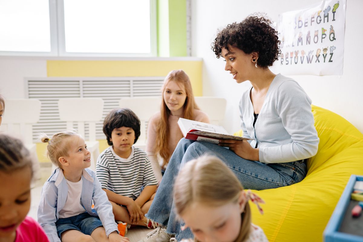 A teacher reading with children in a classroom