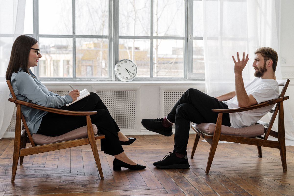 A clinician and client talking in a consulting room