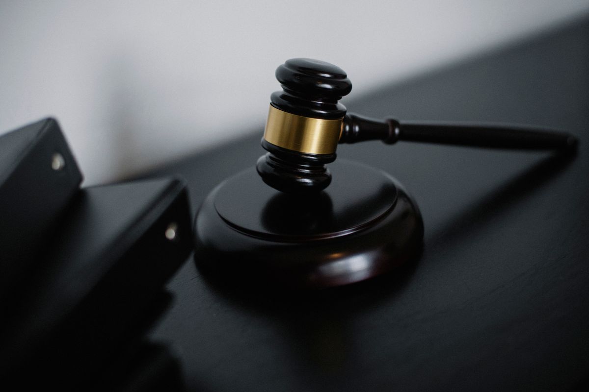 A gavel and case files on a dark desk
