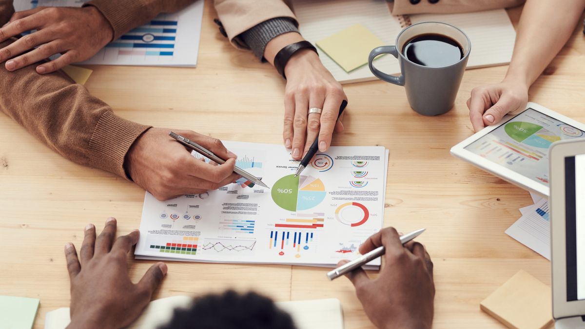 Colleagues reviewing charts around a workplace table